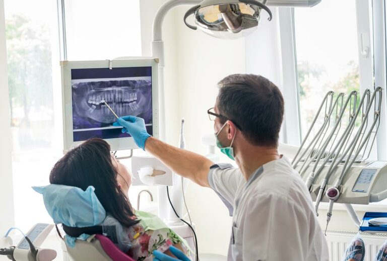 Dentist explaining x-ray photo to a patient in an exam room