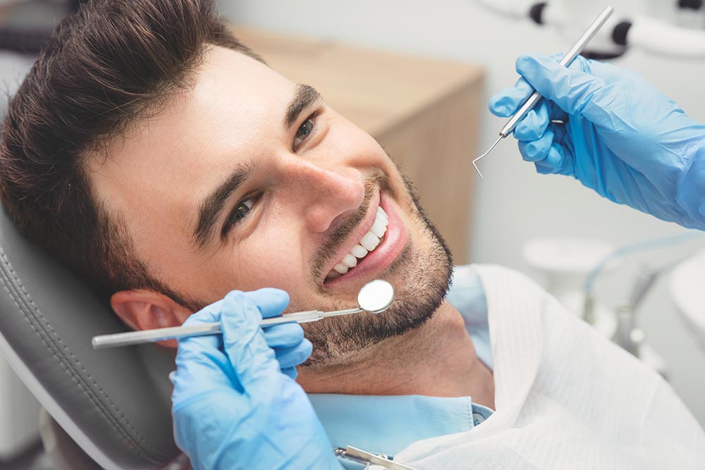 Man with white teeth getting a dental exam